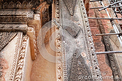 A small squirrel jumping up on a decorated temple wall Stock Photo