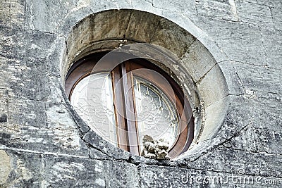 Small stone sculpture on the church window. Chimera gargoyle Stock Photo