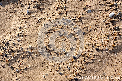 Small stones and fine golden sand with small dunes on a beach Stock Photo