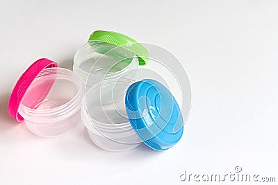 Small storage tubs, with brightly coloured lids on white background. Stock Photo
