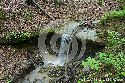 Small waterfall dropping onto rocks Stock Photo