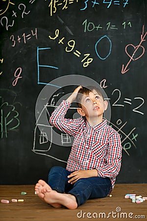 A small student solves a difficult task. Stock Photo