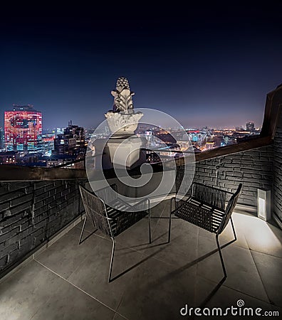 Small terrace with brick walls on night cityscape background Stock Photo