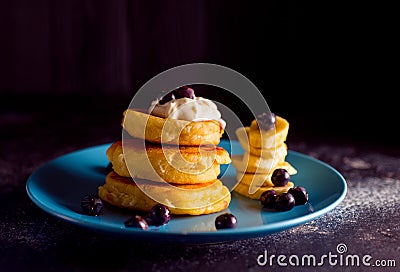 Small thick pancake with berries and sour cream on a beautiful blue plate home cooking tomorrow with goodies Stock Photo