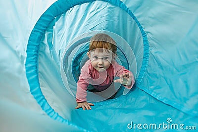 Small toddler playing in a tunnel tube Stock Photo