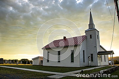 Small town church and cemetery with sun lite clouds Stock Photo