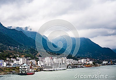 Small town at Yangtze river`s edge with mountain and cloud background Editorial Stock Photo