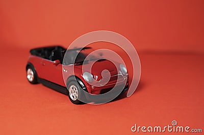 Small toy red SUV, childrens toy car with an open top on a red background Stock Photo