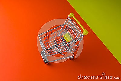 Small trolley on a orange and yellow foreground table. Blackfriday and cybermonday concept Stock Photo