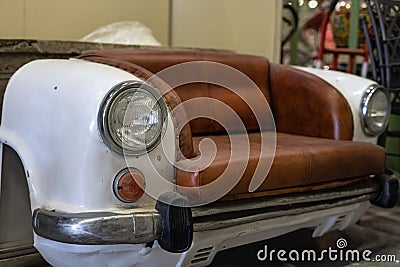 Small Two Seater Leather Sofa in the Shape of a Real White Vintage Car with Round Headlights Stock Photo