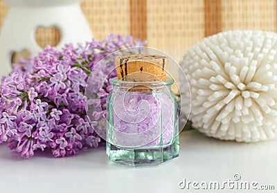 Small vintage glass bottle with purple bath salts epsom salt, foot soak and lilac flowers. Copy space Stock Photo