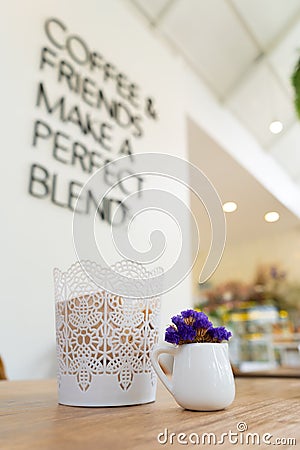 Small violet flower in a white cupin a white vintage cafe Stock Photo