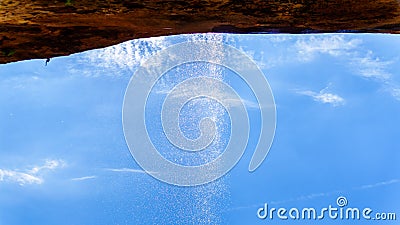 A waterfall flowing over the cliffs overhanging the trail to the Lower Emerald Pool in Zion National Park, Utah, United States Stock Photo