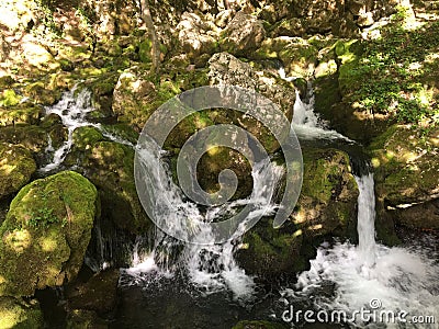 Small waterfall flowing over the large mossy stones Stock Photo