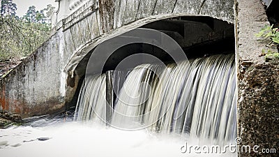 Small waterfall flowing from a samll dam Stock Photo