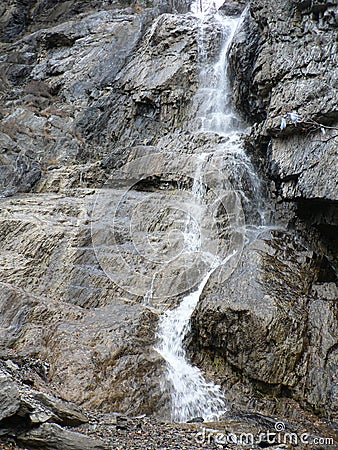 Small waterfall on the gray and brown rocks Stock Photo