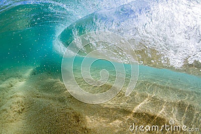 Under water view of Small wave breaking over sandy beach at waimea bay hawaii Stock Photo