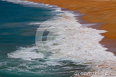 Small waves breaking on the sand of Nazaré Beach, Portugal. Stock Photo