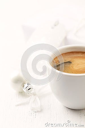 Small, white Christmas bauble and a cup of coffee. Stock Photo