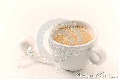 Small, white Christmas bauble and a cup of coffee. Stock Photo