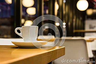 Small White Espresso Cup and Saucer on Table in Chic Retro Cafe Stock Photo