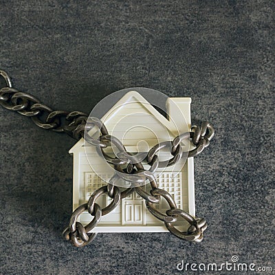 Small white house and a decorative chain on a dark background. C Stock Photo