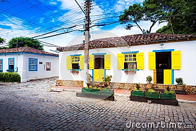 Small white houses with yellow window shutters in Buzios, Braz Stock Photo