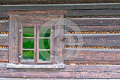 A small window in the wall of an old wooden house Stock Photo