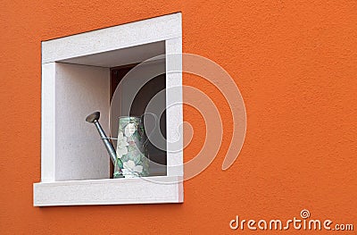 Small window with watering can Stock Photo