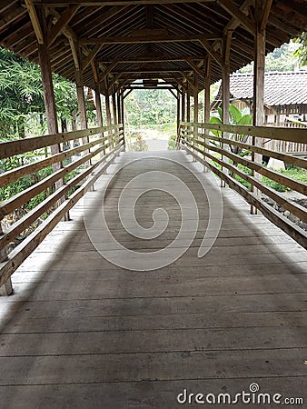 a small wooden bridge with a tiled roof to cross a small river Stock Photo