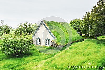 A small wooden church and cemetery Hofskirkja Hof, Skaftafell Iceland. Scenic sunset through tree crowns Stock Photo