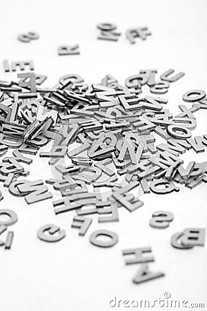 Small wooden letters cut from thin plywood with a laser cutter piled randomly in a pile on a white background. B&W photo Stock Photo