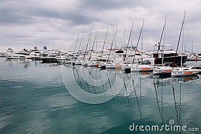 Small yachts in the seaport stand in a row in bad weather Stock Photo