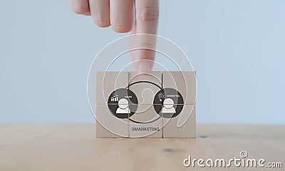 Smarketing concept. Integrated sales and marketing functions to have a common goal and approach. Hands puts the wooden cubes with Stock Photo