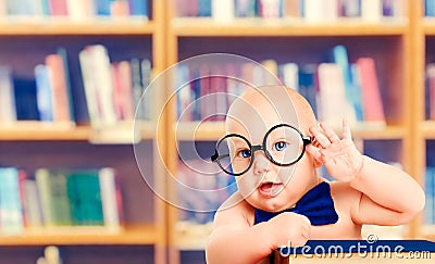 Smart Baby in Glasses with Book, Little Child in School Library Stock Photo