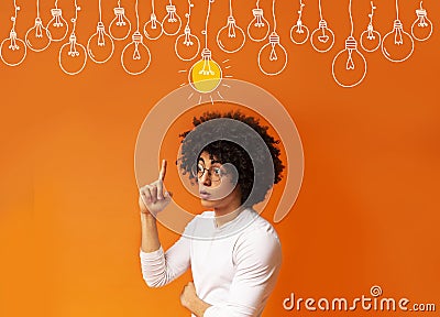 Smart black guy pointing finger up at light bulbs over orange background, collage Stock Photo