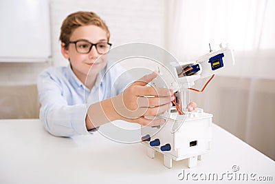 Smart boy testing his robotic device on engineering classes Stock Photo