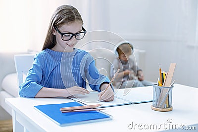 Responsible clever girl doing her homework Stock Photo