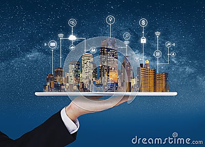 Smart city, building technology, and real estate business. Businessman holding digital tablet with buildings hologram Stock Photo