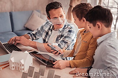 Smart devoted father telling his sons about renewable energy Stock Photo
