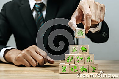 business man investor hand arranging wooden block with agricultural icon on desk Stock Photo