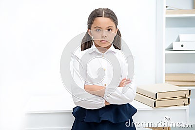 Smart glance. Child girl wears school uniform standing with crossed arms on chest. Schoolgirl smart child looks serious Stock Photo