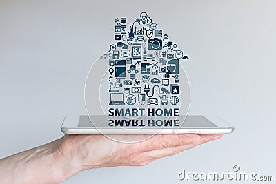 Smart home automation concept. Background with hand holding smart phone and floating text and icons. Stock Photo