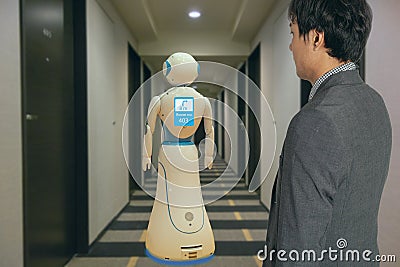 Smart hotel in hospitality industry 4.0 technology concept, robot butler robot assistant use for greet arriving guests, deliver cu Stock Photo