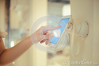 Smart House. The house is controlled from the telephone. The girl clicks on the phone attached to the wall and controls the light Stock Photo