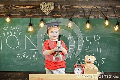 Smart kid concept. First former interested in studying, learning, education. Child on happy face holds microscope. Kid Stock Photo