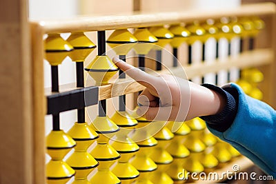 Smart kid counting on soroban abacus. Education, school arithmetic, calculating thinking Stock Photo