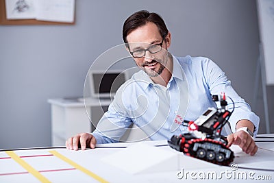 Smart man in glasses testing a little robot Stock Photo