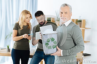 Smart man holding a bin with recycled paper in it Stock Photo