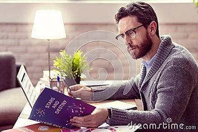 Smart nice man reading a book about astrology Stock Photo